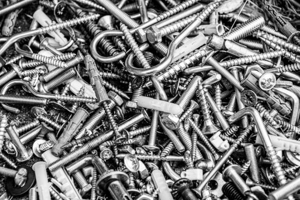 Silver filter photo. Metal fastening manufacture. Hardware for repair or fixing Pile of many assorted metalware bolts and nuts. Black and white photo of work tools closeup. Abstract industrial background for Fathers Day fastening stock pictures, royalty-free photos & images