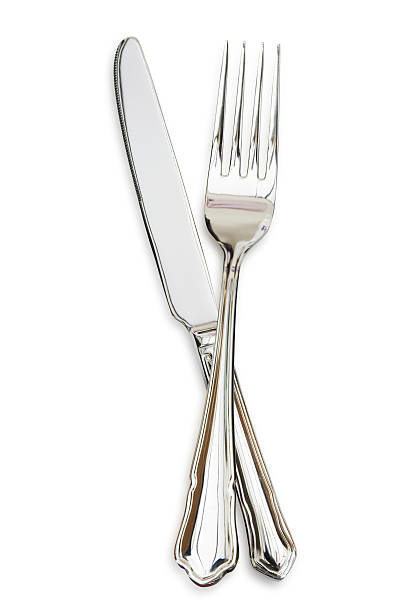 Silver fork sitting across a silver knife Cutlery Knife and Fork, isolated on white. table knife stock pictures, royalty-free photos & images