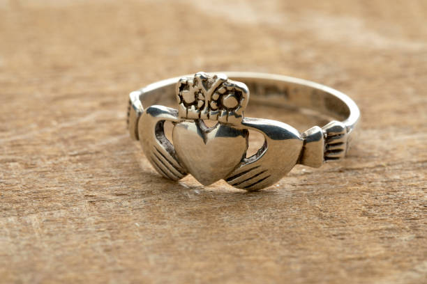 Silver Irish Claddagh ring Silver Irish Claddagh ring on wooden background galway stock pictures, royalty-free photos & images