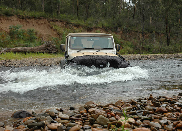 Silver Jeep TJ Wrangler river crossing High Country, Victoria, Australia - January 7, 2009: Silver Jeep TJ Wrangler crossing a river in the Victorian High Country. With "water blind" or "water bra" to create bow wave and protect radiator high country stock pictures, royalty-free photos & images