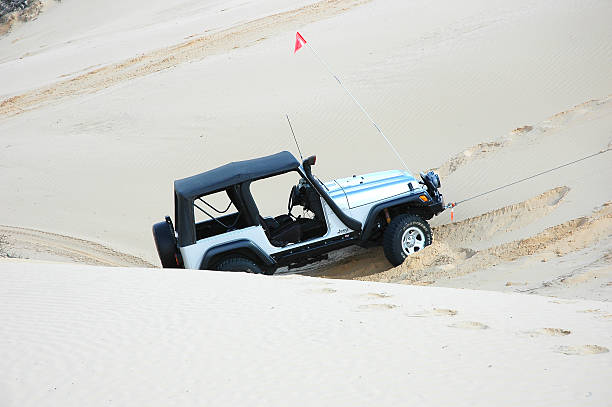 Silver TJ Jeep Wrangler driving in sand dunes, South Australia stock photo