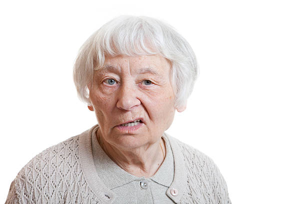 Silver-haired older woman with an annoyed facial expression stock photo