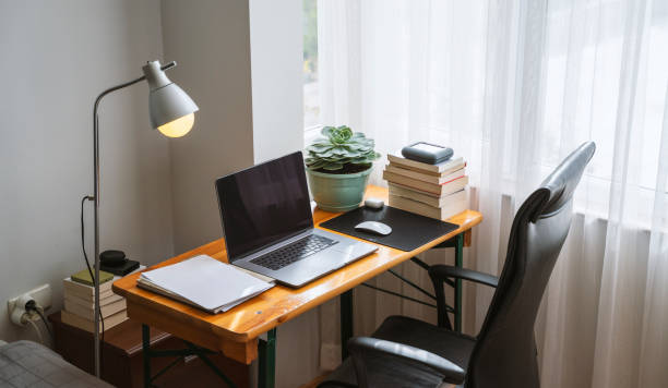 Simple home office setup with a table and laptop stock photo