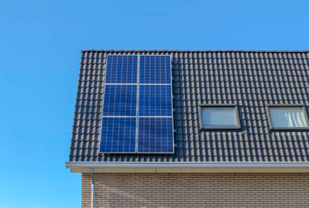 simple image of a roof with solar panels, tiled roof with blue solar panel, energy transition stock photo