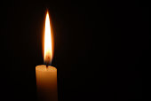 istock Single candle flame on horizontal black background 182175214