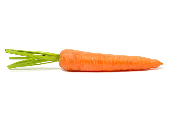 Single orange carrot with stalk on a white surface stock photo