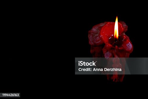 istock Single red burning candle on black. Close-up. 1194426163