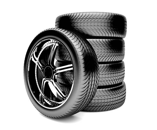 Single tire laying against a stack of four tires stock photo