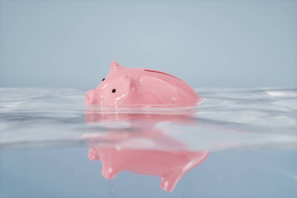 Sinking Piggy Bank Sinking piggy bank in the water. recession stock pictures, royalty-free photos & images