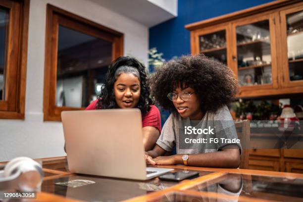 Sisters using laptop together at home