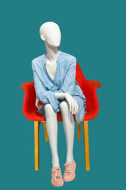 Sitting female mannequin. Sitting female mannequin wearing blue casual dress, isolated on blue background. No brand names or copyright objects. mannequin stock pictures, royalty-free photos & images