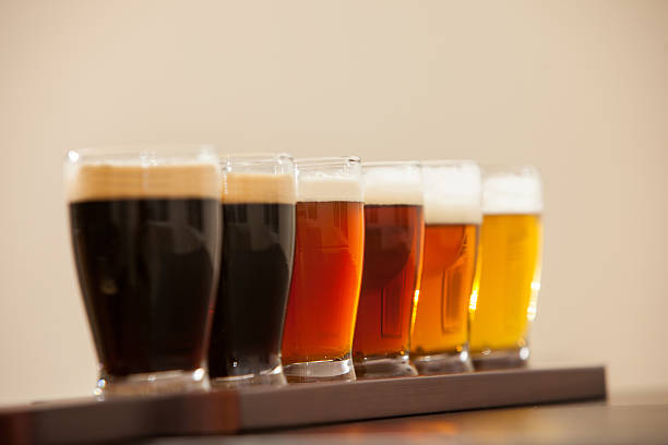 Six beer samples in small glasses on a bar. stock photo