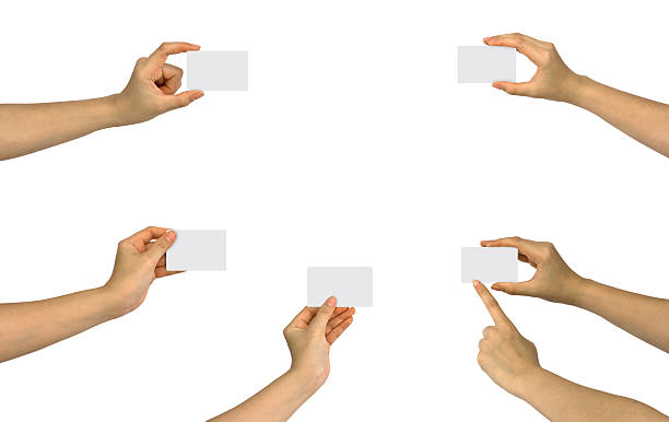 Six hands holding up five blank business cards stock photo
