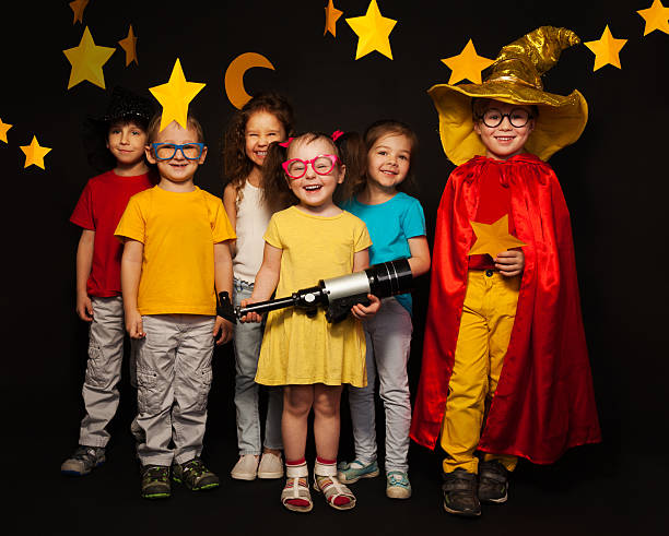 Six kids in stargazers costumes with telescope stock photo