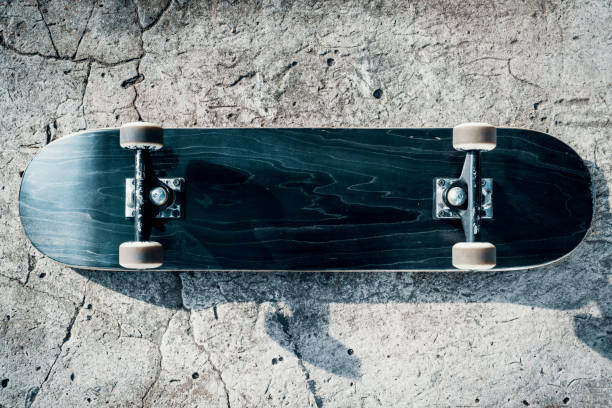 skateboard auf betonboden im skatepark - skateboard stock-fotos und bilder