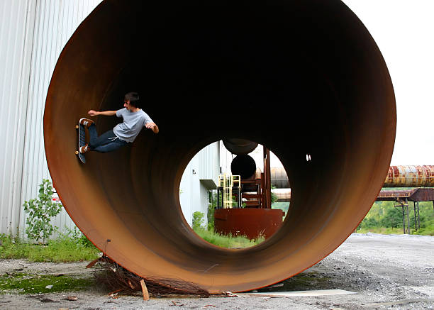 Skateboarder riding full pipe stock photo