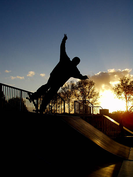 Skater on ramp in sunset Silhouette of skater at skatepark with sun setting behind skeable stock pictures, royalty-free photos & images
