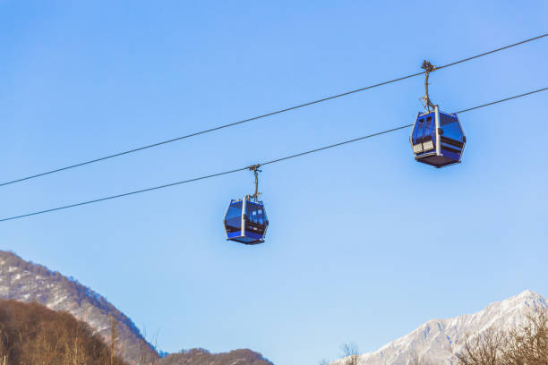 Ski lift cable, Ropeway, and cableway transport system for skiers with fog on valley background. stock photo