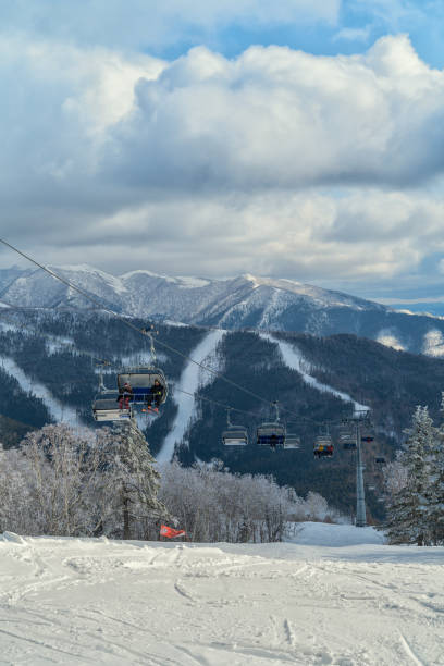 Ski resort - Mountain Air in Yuzhno-Sakhalinsk, Russia - Ski lift with people in the mount Bolshevik. stock photo