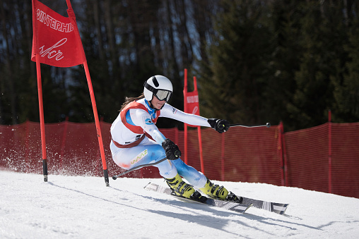 Female ski athlete performing during the FIS Alpine Ski World Cup Competition. Special simulated FIS World Cup shooting.