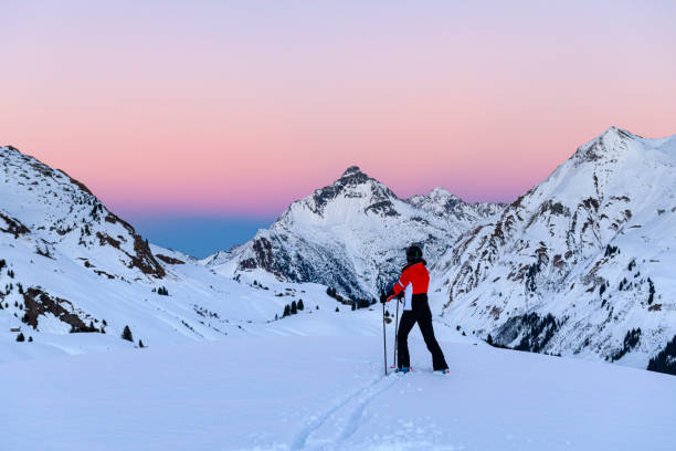 Skier in ski-resort Lech after sunset Skier looking at the landscape in ski-resort Lech after sunset during winter. Vorarlberg, Austria lechtal alps stock pictures, royalty-free photos & images