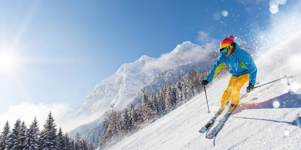 skifahrer abfahrt im hochgebirge - skifahren stock-fotos und bilder