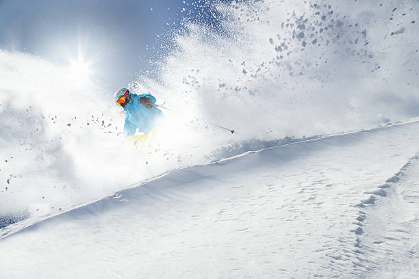 Skier skiing downhill in high mountains stock photo