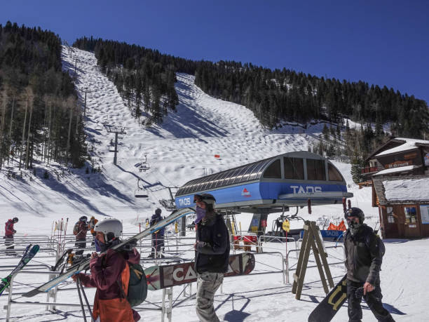Skiers and snowboarders at the base of Taos, New Mexico ski resort stock photo