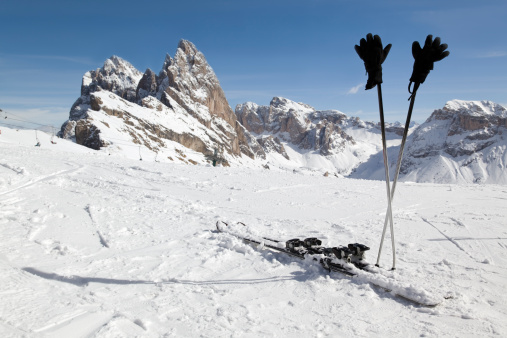 Skiing gear in front of mountain peak in the Dolomites (European alps, Alto Adige, Italy).