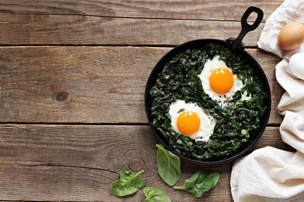 Skillet Poached Eggs with Spinach Skillet Poached Eggs with Spinach. Overhead view poached food photos stock pictures, royalty-free photos & images