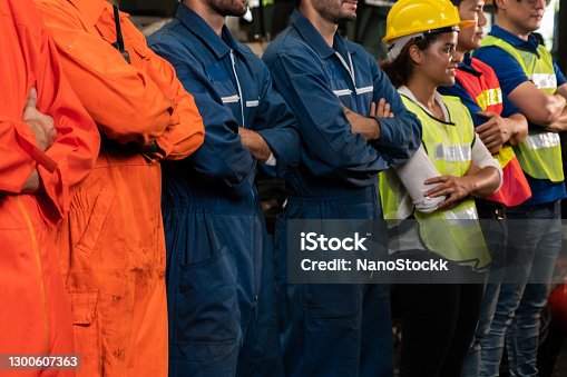 istock Skillful worker stand together showing teamwork in the factory . 1300607363
