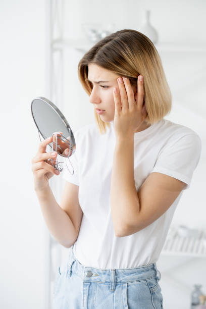 skin aging dermatology problem woman face mirror stock photo