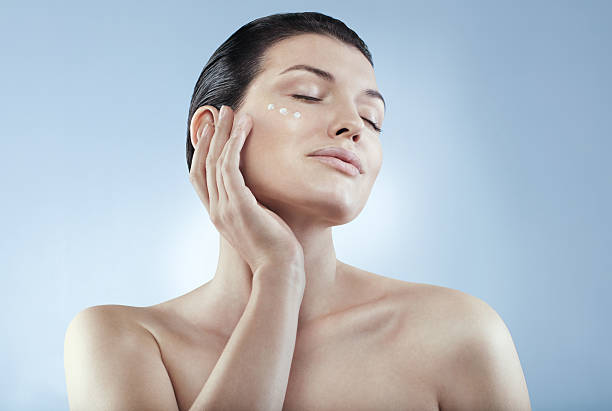 Skin care. Portrait of woman applying moisturizer cream stock photo
