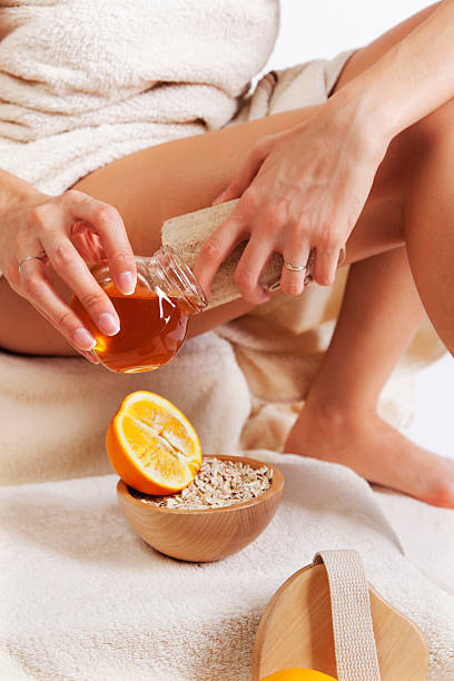Skin treatment with natural sponge, honey and orange. Close-up stock photo