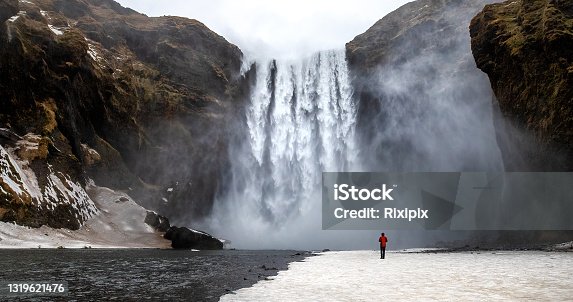 istock Skogafoss waterfall with solitary person 1319621476
