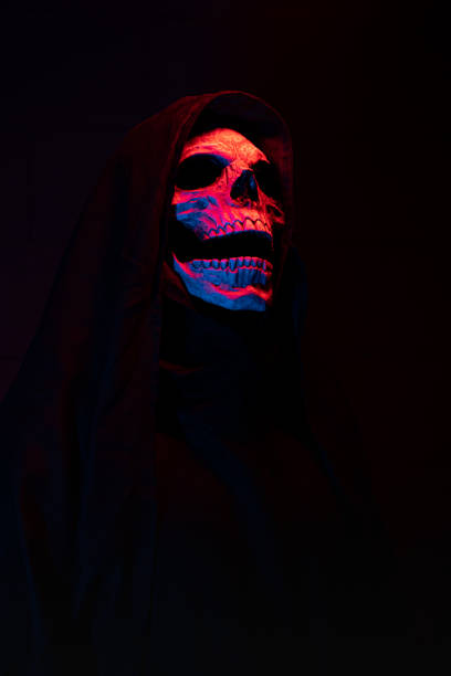 Skull illuminated with red, laughs, on black background with free space for text. stock photo