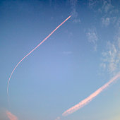 istock Sky with aircraft vapor trails clouds at sunset 1289203827