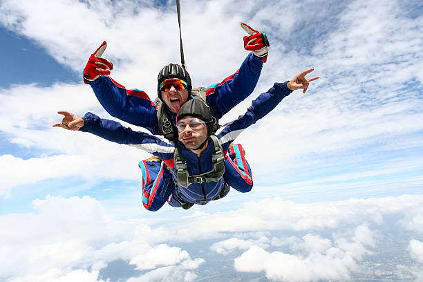 Skydiving photo. Tandem. Tandem jump in the sky with clouds. parachuting stock pictures, royalty-free photos & images