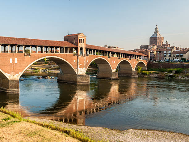 Skyline of Pavia, with "Ponte Coperto" over the river Ticino Skyline of Pavia, with famous "Ponte Coperto" over the river Ticino; the cathedral in the background covered bridge stock pictures, royalty-free photos & images