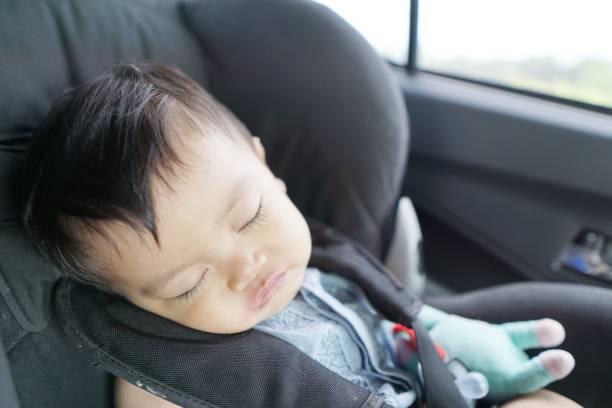 Sleeping baby in a car seat and looks comfortable stock photo