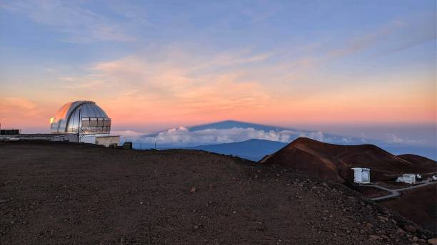 Sleeping Giant Sunrise on top of dormant volcano with its own shadow projected against the distant atmosphere and large telescope in the foreground. Manua Kea, Island of Hawai'i. mauna kea stock pictures, royalty-free photos & images