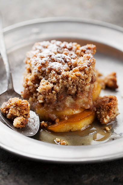 Slice of apple crumble on tin plate with spoon stock photo