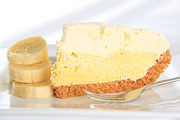 Slice of banana cream pie on plate with slices of banana stock photo