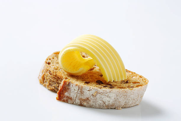 slice of bread with butter - boter stockfoto's en -beelden