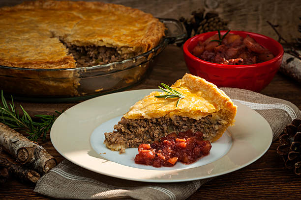 Slice of meat pie Tourtiere Slice of traditional pork meat pie Tourtiere with apple and cranberry chutney from Quebec, Canada. meat pie stock pictures, royalty-free photos & images