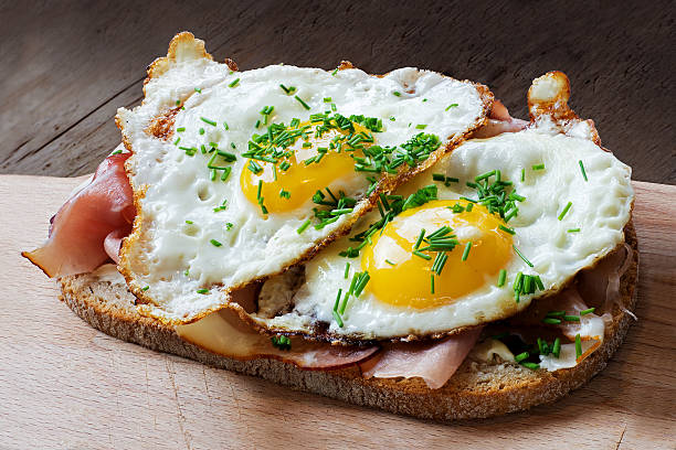 slice of rustic bread with ham  and fried eggs slice of rustic bread with ham or bacon and fried egg, typical  in germany called strammer max fried egg photos stock pictures, royalty-free photos & images