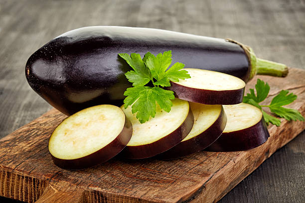 sliced eggplant on cutting board stock photo