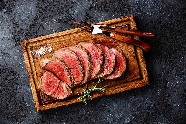Sliced grilled tenderloin Steak roastbeef Sliced grilled tenderloin Steak roastbeef on wooden cutting board on dark background beef stock pictures, royalty-free photos & images