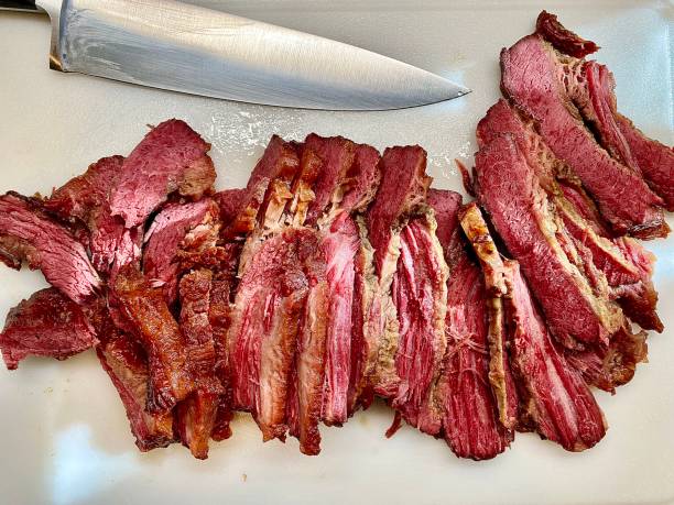 Sliced Guinness Corned Beef Brisket Big flat of corned beef brisket cooked in Guinness beer, being sliced. Grilled Corned Beef Brisket stock pictures, royalty-free photos & images