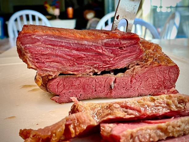 Sliced Guinness Corned Beef Brisket Big flat of corned beef brisket cooked in Guinness beer, being sliced. Grilled Corned Beef Brisket stock pictures, royalty-free photos & images